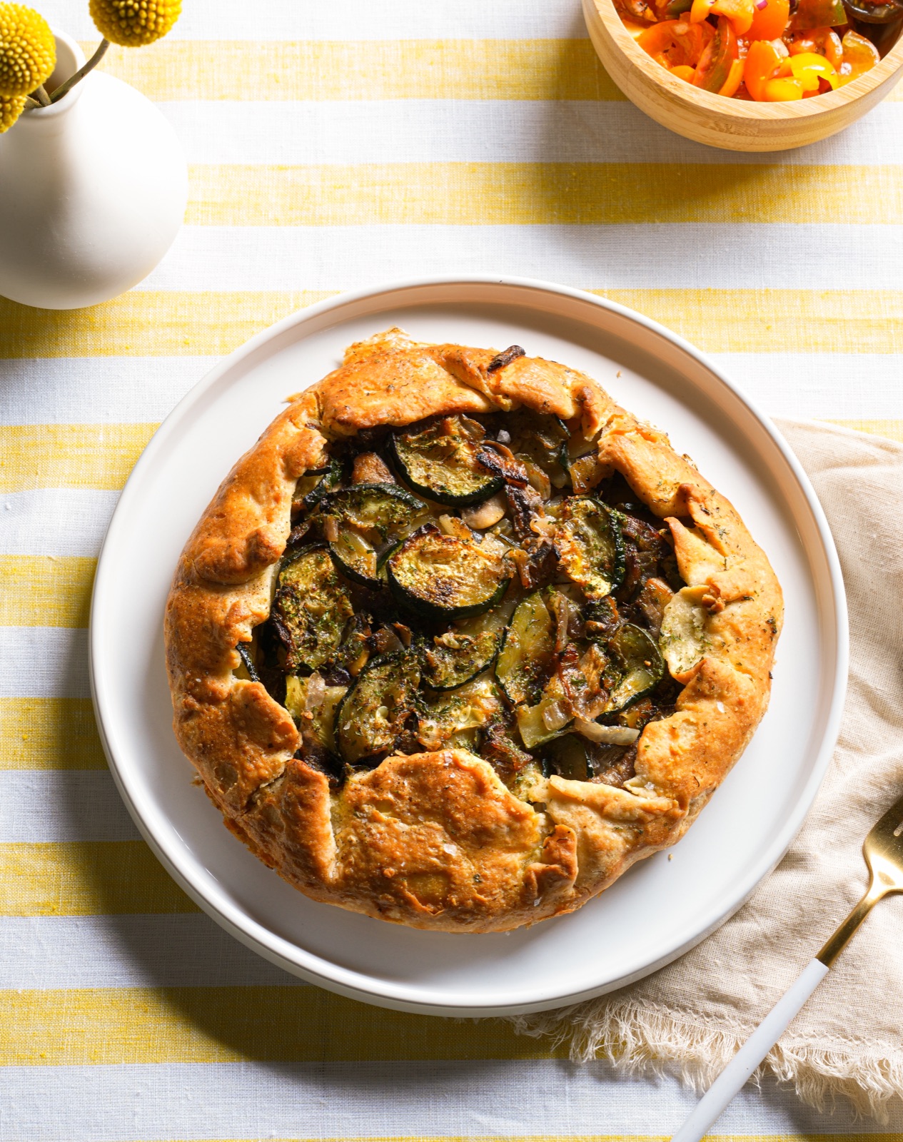 Whole savory vegetable galette on a white plate