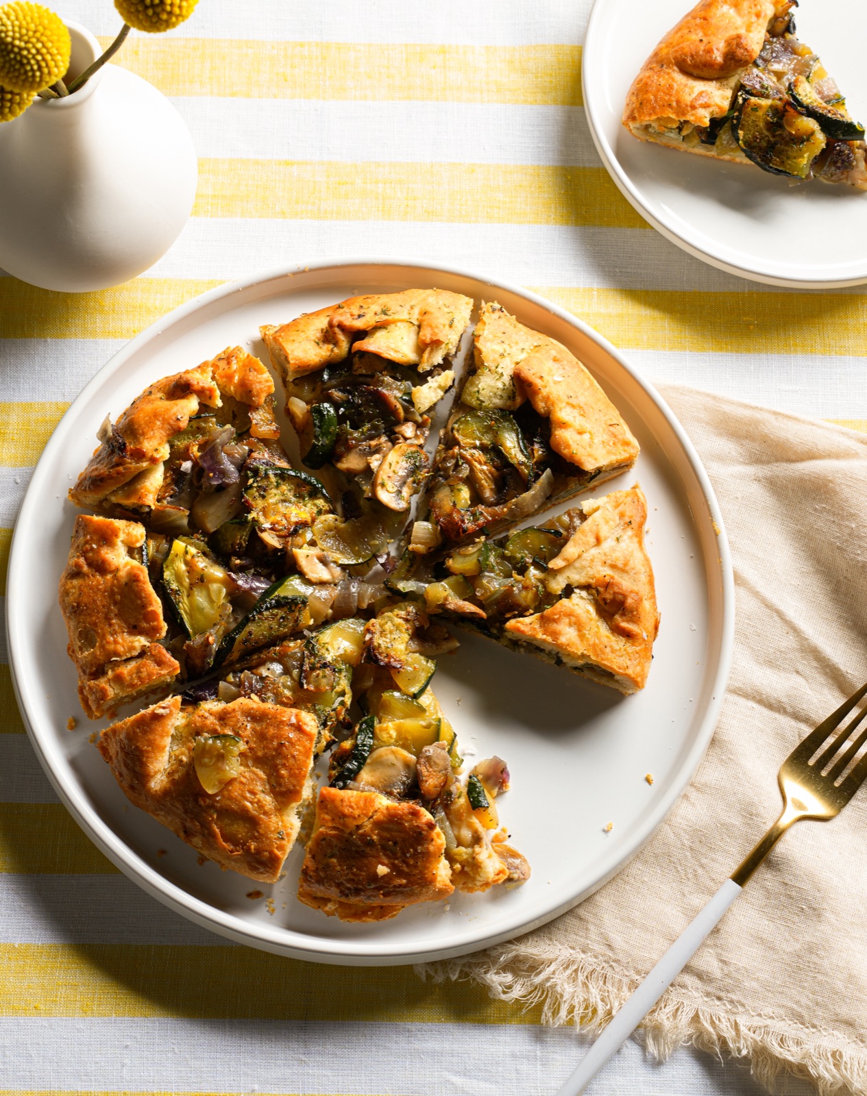 Sliced savory vegetable galette on a styled table