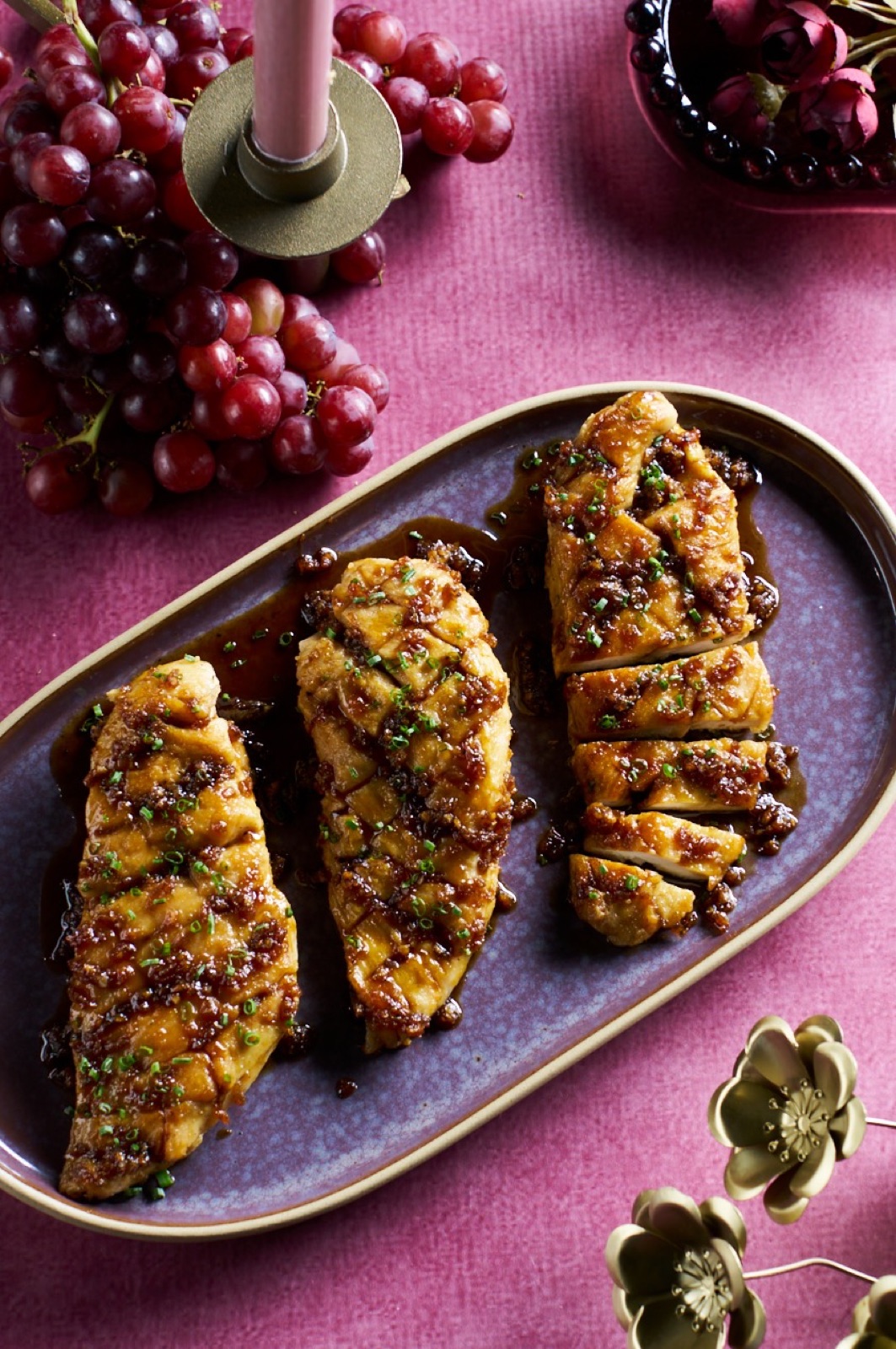 Glazed chicken arranged on a plum-colored serving plate