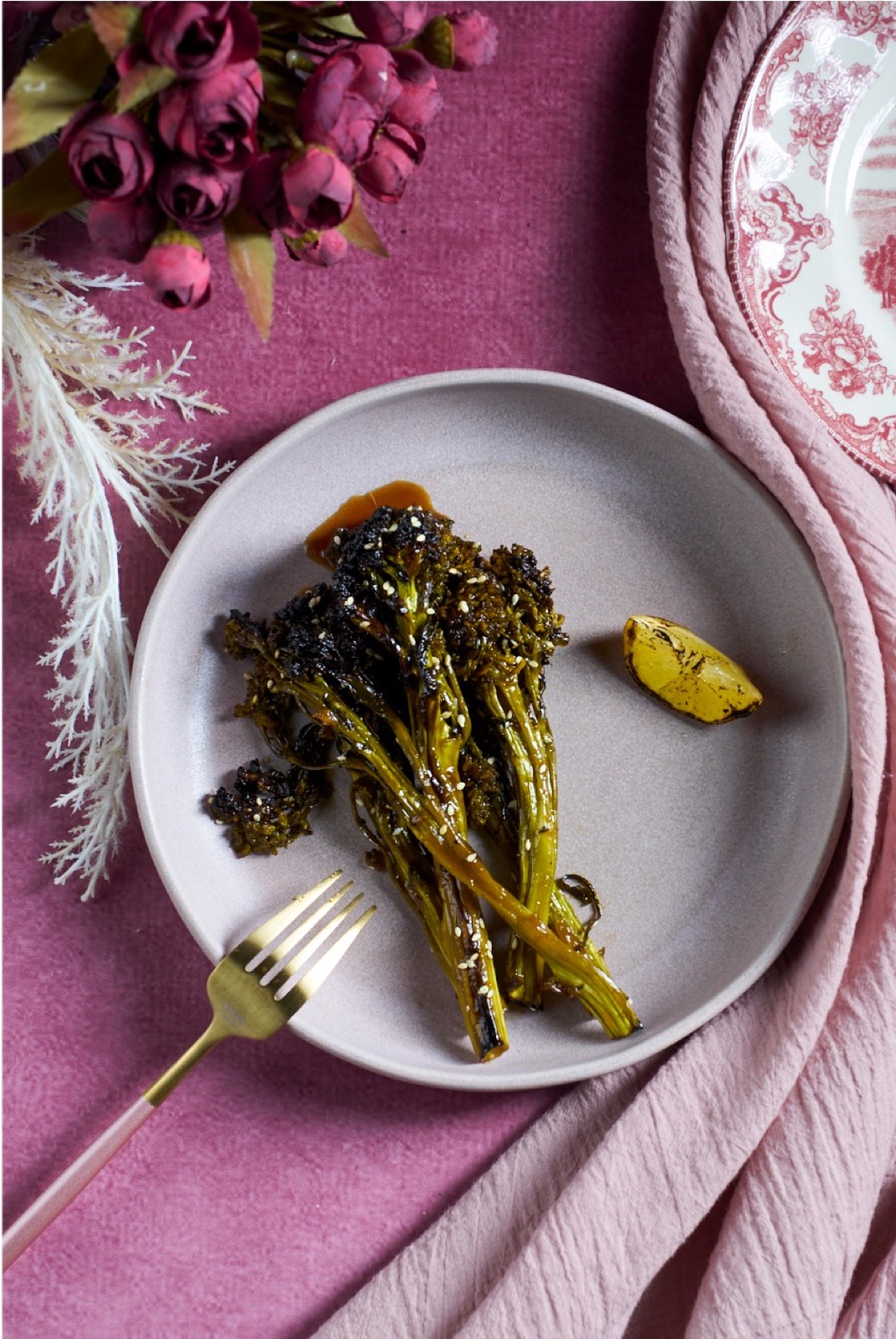 Glazed broccolini plated with a charred lemon wedge