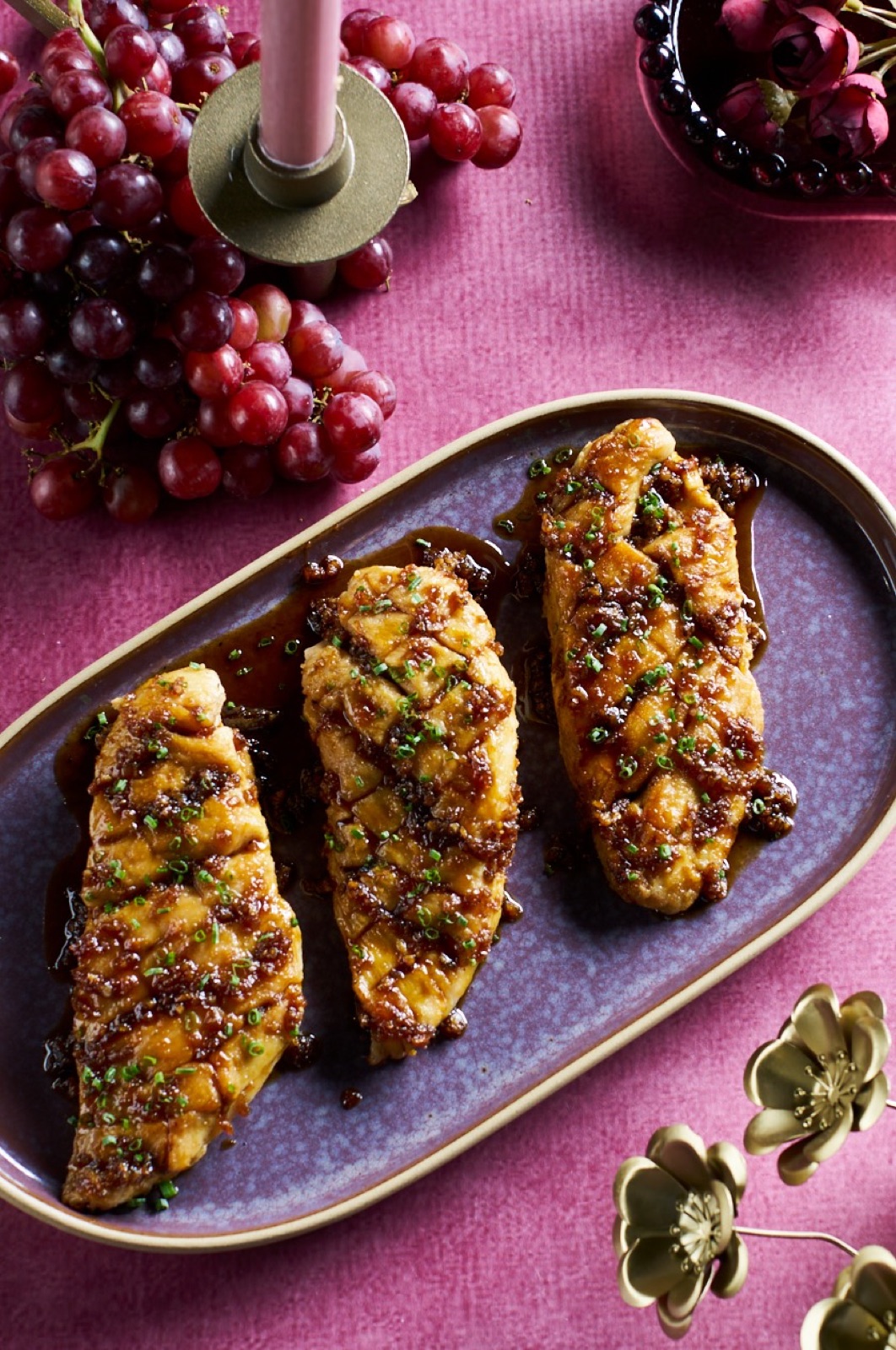 Three portions of glazed chicken in a styled editorial setting