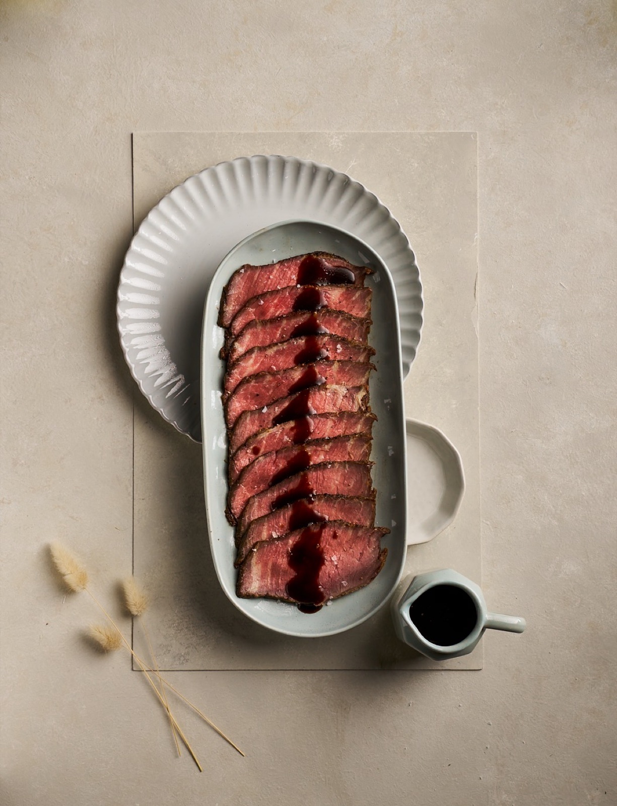Sliced roast beef with dark sauce in an overhead composition