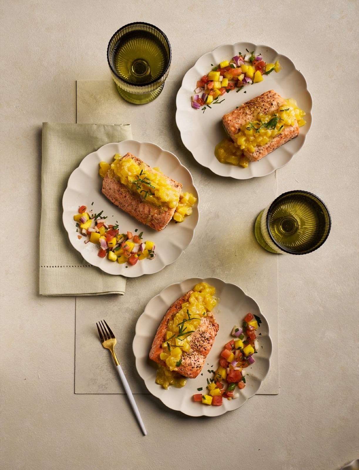 Three salmon plates with yellow sauce and fresh salsa